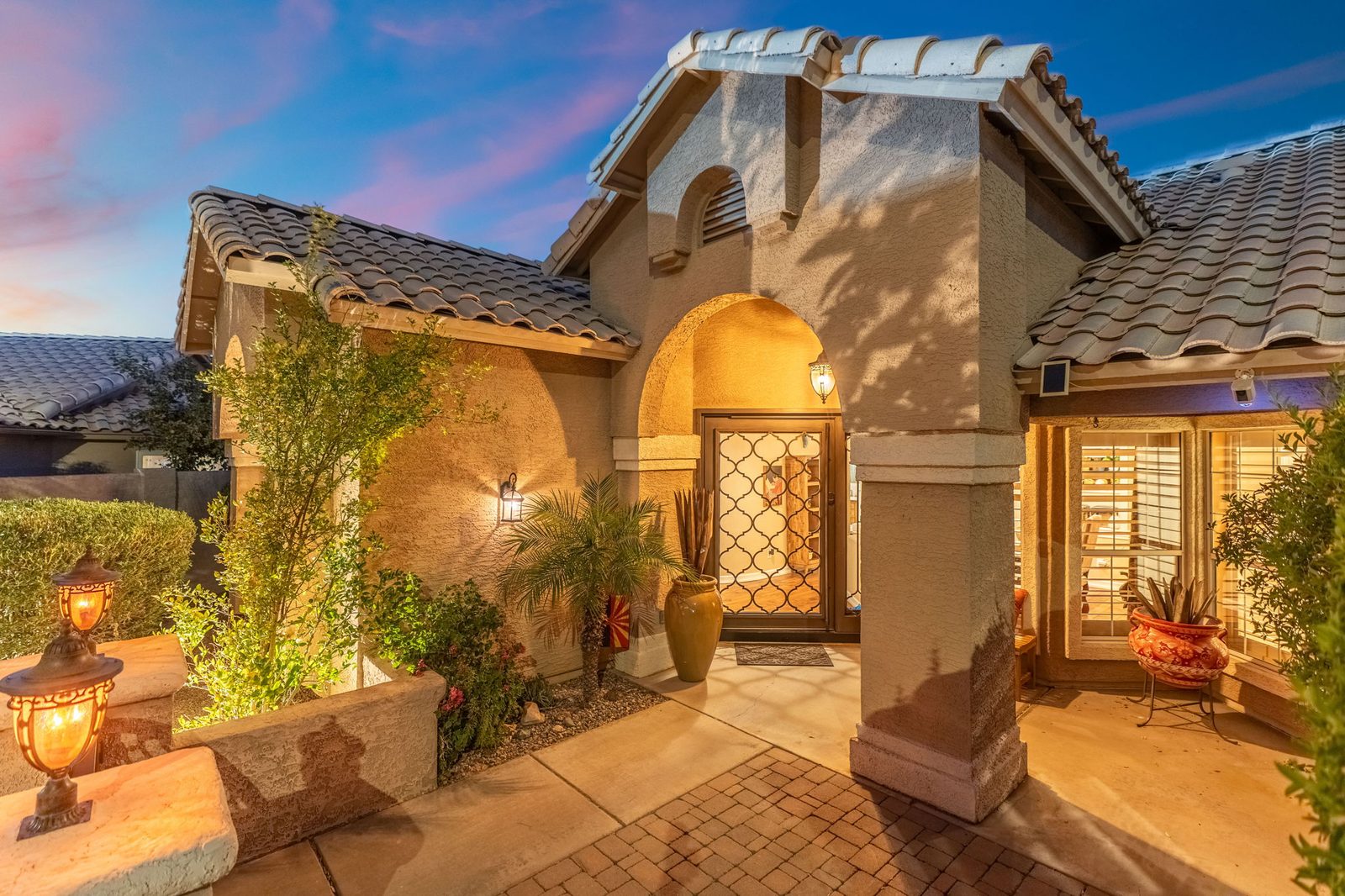 Arched front entry of Casa Amoroso lit at twilight
